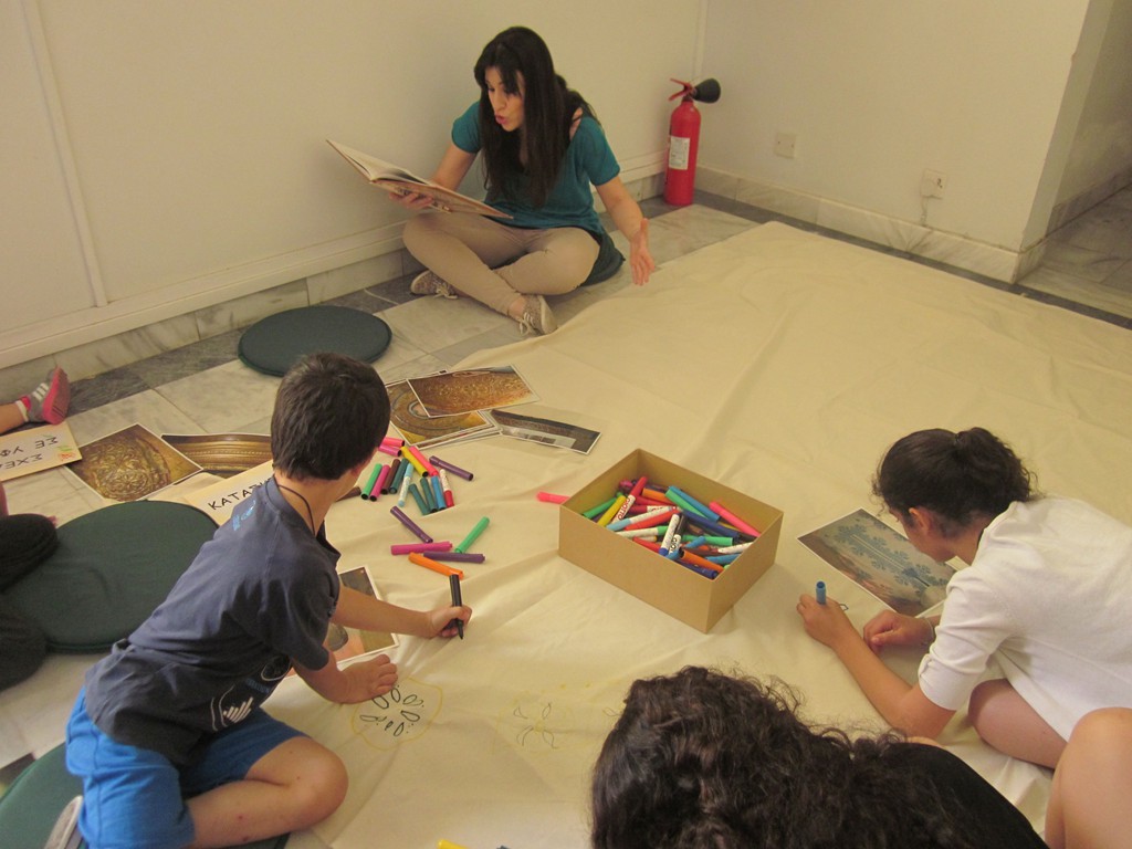 Εικαστικός σταθμός: παιδιά ζωγραφίζουν μοτίβα από ξυλόγλυπτες παραστάσεις ενώ ακροώνται μεσαιωνικό παραμύθι από επαγγελματία ηθοποιό. 