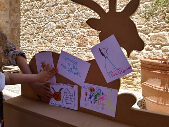 Τα παιδιά τοποθέτησαν τα σκίτσα τους μαζί με τα μηνύματά τους: «Αγαπούμε τα ζώα», «Τα ζώα είναι φίλοι μας», πάνω στην ξύλινη γίδα, που τοποθετήθηκε στο προαύλιο, εμπνευσμένη από το έργο του καλλιτέχνη, Χρίστου Χρίστου με τίτλο «Το κοπάδι», 1991, Δημοτική Πινακοθήκη Πάφου. 